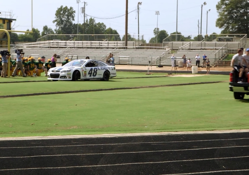 Why Is NASCAR's Jimmie Johnson Driving Onto a High School Football Field?